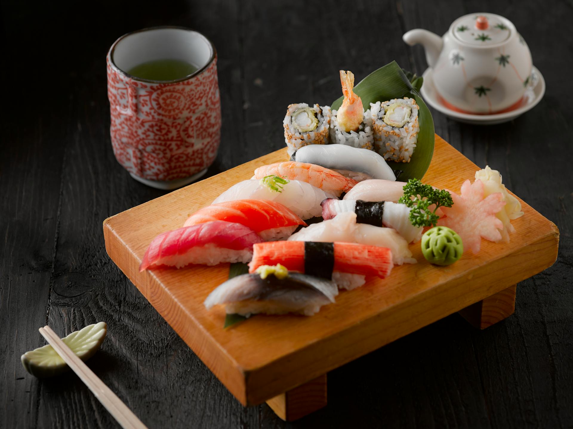 Assorted sushi and nigiri on a traditional wooden board at Nipona